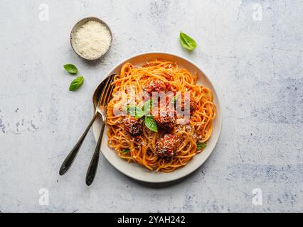 Blick von oben auf den Teller mit Spaghetti und Fleischbällchen auf hellem Hintergrund. Stockfoto