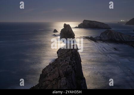 Mondschein über der felsigen Küste an Playa de La Arnia, Spanien Stockfoto