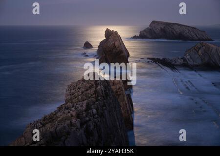 Mondschein über der felsigen Küste an Playa de La Arnia, Spanien Stockfoto