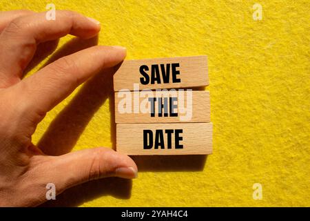 Speichern Sie die Datumsmeldung auf Holzblöcken mit gelbem Hintergrund. Datumssymbol für konzeptionelles Speichern. Stockfoto