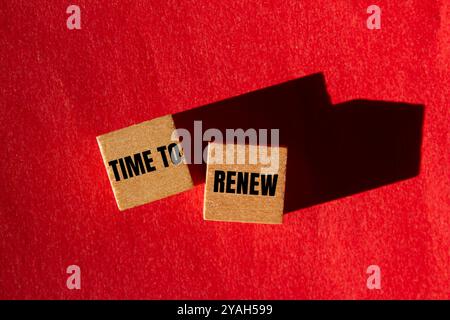 Es ist Zeit, die Nachricht auf Holzwürfeln mit rotem Hintergrund zu erneuern. Konzeptionelle Zeit für Erneuerung des Symbols. Kopierbereich. Stockfoto