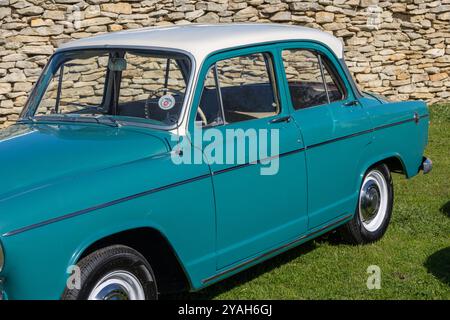 Türkisfarbener simca aronde Oldtimer mit weißem Dach, das auf Gras in der Nähe einer Steinmauer geparkt ist Stockfoto