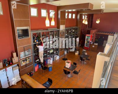 Die Arbeiter führen Regale mit lokalen Weinen aus Cafayate zum Verkauf im Museo de la Vid y el Vino in Cafayate, Argentinien. Stockfoto