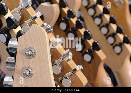 Gruppe von Gitarren, traditionelle Saiteninstrumente. Nahaufnahme von Kopfstöcken, abstrakter Hintergrund aus der Musikindustrie. Stockfoto