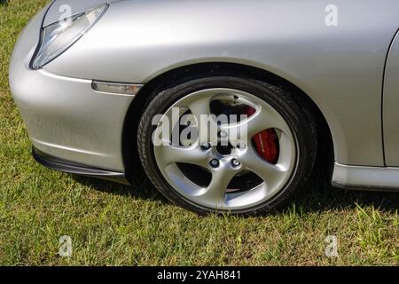 der silberne porsche 911 Turbo parkt auf Gras und zeigt sein 5-Speichen-Leichtmetallrad und den roten Bremssattel Stockfoto