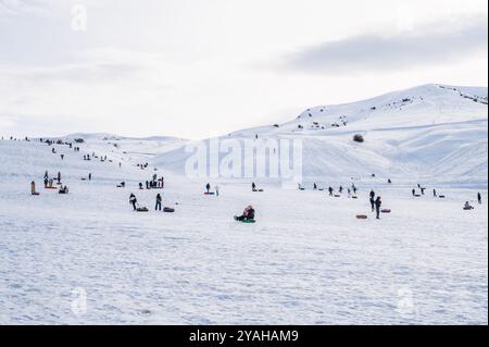 Die Menschen entspannen sich und Rollen die Rutsche auf Tubing im Winter in der Natur in den Bergen Kasachstans herunter. Shymkent, Kasachstan - 27. Januar 2024 Stockfoto