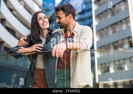 Junge glückliche Paare, die auf ihren Immobilienmakler warten, um ihnen die Tour durch ihre neue Wohnung zu geben, um sie zu kaufen oder zu vermieten. Mann und Frau warten ab Stockfoto