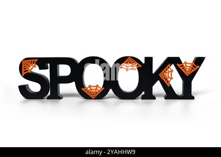 Halloween Dekor Holzbuchstaben mit der Aufschrift „Spooky“ mit orangefarbenen Spinnweben auf weißem Hintergrund Stockfoto