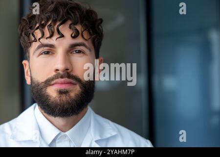 Mann Zahnarzt mit Zahnspangen, der die Bedeutung der Zahnpflege in der Kieferorthopädie zeigt, während er um die Kamera lächelt Stockfoto