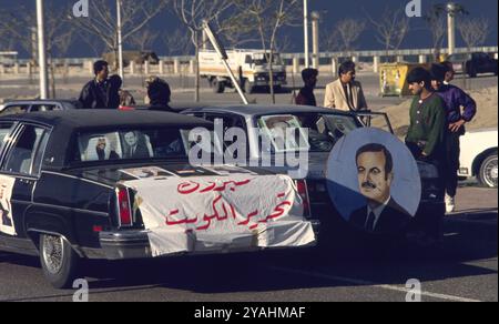 Erster Golfkrieg: 8. März 1991 Autos auf der Arabian Gulf Street in Kuwait City mit Plakaten und Porträts des Emirs und des Kronprinzen von Kuwait und des Präsidenten Hafez al-Assad von Syrien. Dies geschah in den Tagen nach der Befreiung Kuwaits durch Koalitionstruppen. Stockfoto