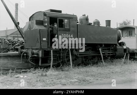 US-Klasse 0-6-0T (3F) Nummer 30064 bei der Bluebell Railway im Jahr 1976. 30064 wurde 1943 in Vulcan Iron Works in den USA als USATC-Klasse (United States Army Transportation Corps) gebaut, die für Rangieraufgaben in Europa und Nordafrika während des Zweiten Weltkriegs ausgelegt war. Die 1967 außer Betrieb genommene Nummer 64 wurde unter Konservierung und späterer Lagerung gelagert, bevor sie 1971 an die Bluebellbahn ging. Stockfoto