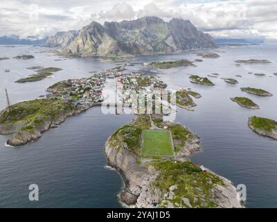 Malerisches Inseldorf mit einzigartigem Küstenfußballfeld in der majestätischen norwegischen Fjordlandschaft Stockfoto