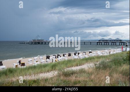 28.07.2024, Deutschland, Mecklenburg-Vorpommern, Heringsdorf - Europa - über den leeren Sandstrand und die Pier am Balti ziehen dunkle Wolken Stockfoto