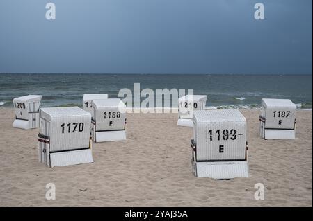 28.07.2024, Deutschland, Mecklenburg-Vorpommern, Heringsdorf - Europa - Dunkler Himmel an einem bewölkten Tag über leeren Liegen im Badeort H Stockfoto