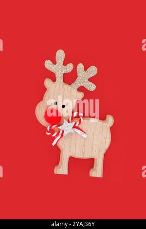 Retro-Holzdekoration mit roter Nase und rudolph-Rentier am Heiligabend. Lustiges Weihnachtsmann-Helfer-Fantasiesymbol für die festliche Weihnachtsfeiertage. Stockfoto