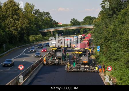 20.07.2024, Deutschland, Nordrhein-Westfalen, Essen - Straßenbau, Asphaltfertiger und Straßenwalzen legen neuen, offenporigen FL¸Sterasphalt auf Stockfoto