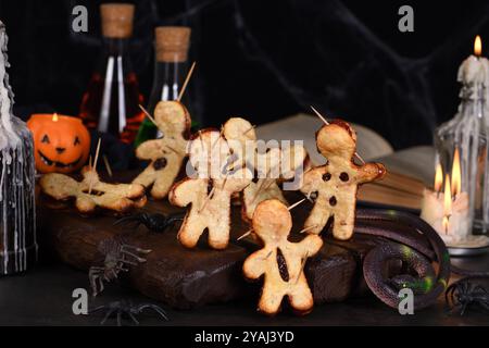 Voodoo-Kekse aus Blätterteig mit Marmelade und mit Holzspießen durchstochen. Idee für die Halloween-Party Stockfoto