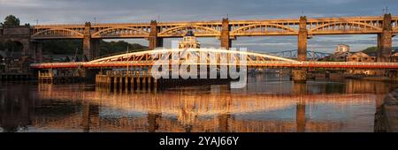 NEWCASTLE UPON TYNE, Großbritannien - 2. AUGUST 2012: Panoramablick auf die Swing Bridge und die High Level Bridge über den Fluss Tyne, beleuchtet von der frühen Morgensonne in N Stockfoto
