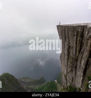 Preikestolen, Norwegen - 7. August 2022: Spektakuläres Bild der Preikestolen Klippe, auch bekannt als Kanzel Rock, in Norwegen vor dem nebeligen Lysefjor Stockfoto