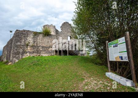 Die mittelalterliche Burg Solimbergo, Bruchteil der Sequals in Friaul. Im Vordergrund steht ein großes Zeichen mit Informationen über seine Geschichte. Stockfoto