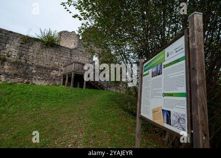 Die mittelalterliche Burg Solimbergo, Bruchteil der Sequals in Friaul. Im Vordergrund das Schild mit historischen Informationen. Ruinen sind auf einem Hügel. Stockfoto