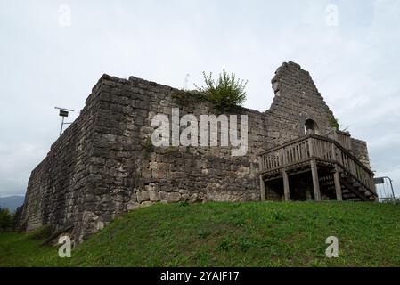 Die mittelalterliche Burg Solimbergo, Bruchteil der Sequals in Friaul. Im Vordergrund befindet sich ein Schild mit historischen Informationen. Die alte Ruine ist auf einem Hügel. Stockfoto