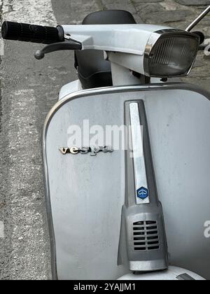 Rom, Italien - 6. Juni 2023: Die Vorderseite eines silbernen Vespa-Rollers von Piaggio wird tagsüber in vertikaler Ansicht auf einer Stadtstraße geparkt. Stockfoto