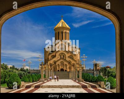 Geschnitzte Steinsäulen und eine breite Treppe führen bei voller Sonne zur imposanten heiligen dreifaltigkeitskirche von tiflis georgien Stockfoto