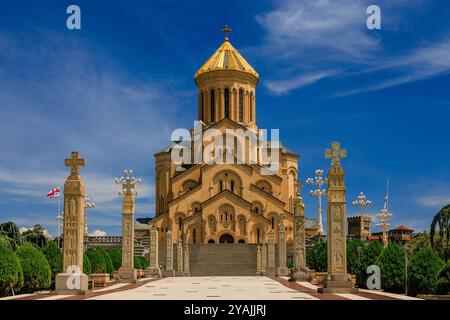 Geschnitzte Steinsäulen und eine breite Treppe führen bei voller Sonne zur imposanten heiligen dreifaltigkeitskirche von tiflis georgien Stockfoto