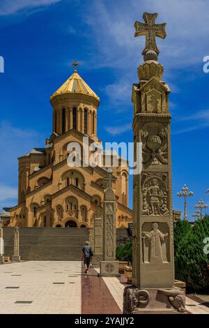 Geschnitzte Steinsäulen und eine breite Treppe führen bei voller Sonne zur imposanten heiligen dreifaltigkeitskirche von tiflis georgien Stockfoto