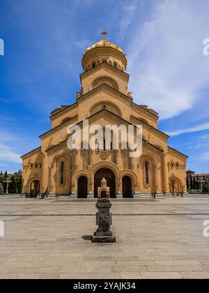 Die imposante Kathedrale der Heiligen dreifaltigkeit in tiflis georgien an einem sonnigen blauen Himmel steht eine Miniaturkathedrale im Vordergrund Stockfoto