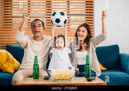 Eine glückliche Familie genießt den Nervenkitzel eines Fußballspiels zu Hause Stockfoto