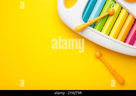 Buntes Xylophon auf gelbem Hintergrund. Leerzeichen für Text. Draufsicht Stockfoto