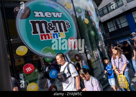 Touristen und einheimische Besucher im West End am Leicester Square vor dem M&Ms Store am 28. Juli 2024 in London, Großbritannien. London ist eines der weltweit führenden Reiseziele und spielt eine entscheidende Rolle im Tourismusgeschäft des Vereinigten Königreichs. Die Stadt zieht jedes Jahr Millionen internationale Besucher sowie einheimische Touristen und Tagesausflügler an, sodass einige Stadtteile im Zentrum Londons zu Zeiten voller Menschen sind. Der Tourismus- und Tourismussektor im Vereinigten Königreich trägt mit rund 700.000 Beschäftigten erheblich zur Wirtschaft bei. Stockfoto