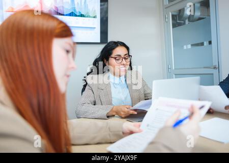 Zwei junge Frauen, die an einem kollaborativen Geschäftsprojekt in einem Co-Working-Büro arbeiten. Stockfoto