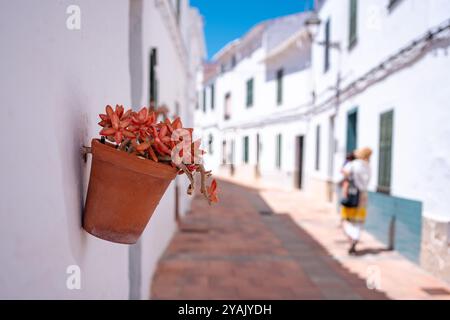 Traditionelle Gasse in einer spanischen Kleinstadt an einem sonnigen Sommertag mit klarem blauem Himmel. Beispiel der klassischen Architektur eines spanischen Dorfes auf Menorca Stockfoto