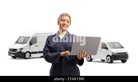 Weibliche Arbeiterin mit Lieferwagen, die einen Laptop auf weißem Hintergrund benutzen Stockfoto