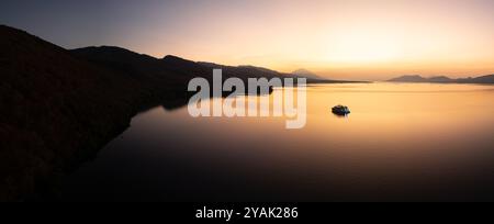 Sonnenaufgang Silhouetten ein kleines Schiff in der Nähe der wunderschönen Insel Adoenara auf den Kleinen Sunda-Inseln Indonesiens. Dieser Bereich befindet sich im Feuerring. Stockfoto