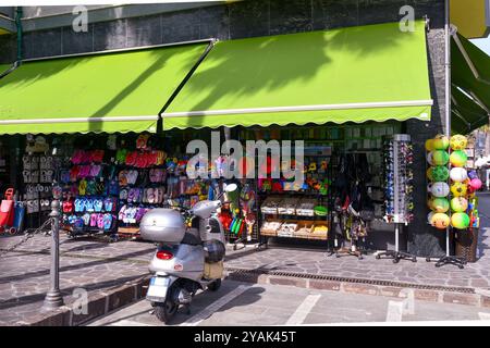 Außenansicht eines Touristengeschäfts mit Strandspielzeug, Flip-Flops und Souvenirs an der Promenade der Küstenstadt Alassio, Savona, Ligurien, Italien Stockfoto