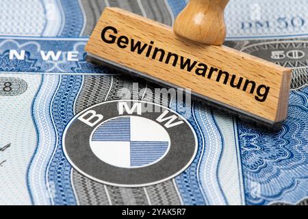 Gewinnwarnung für BMW ein Holzstempel ist beschriftet mit dem Aufdruck: Gewinnwarnung, über einer BMW-Aktie mit Firmen-Logo Symbolbild *** Gewinnwarnung für BMW Eine Holzmarke ist mit den Worten Gewinnwarnung beschriftet, über einer BMW-Aktie mit Firmenlogo symbolischem Bild Stockfoto