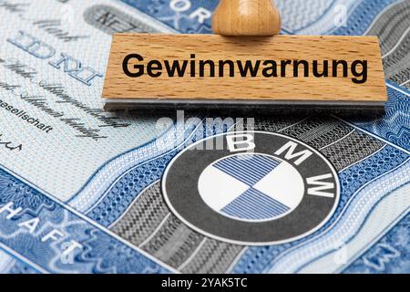 Gewinnwarnung für BMW ein Holzstempel ist beschriftet mit dem Aufdruck: Gewinnwarnung, über einer BMW-Aktie mit Firmen-Logo Symbolbild *** Gewinnwarnung für BMW Eine Holzmarke ist mit den Worten Gewinnwarnung beschriftet, über einer BMW-Aktie mit Firmenlogo symbolischem Bild Stockfoto