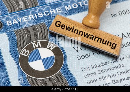 Gewinnwarnung für BMW ein Holzstempel ist beschriftet mit dem Aufdruck: Gewinnwarnung, über einer BMW-Aktie mit Firmen-Logo Symbolbild *** Gewinnwarnung für BMW Eine Holzmarke ist mit den Worten Gewinnwarnung beschriftet, über einer BMW-Aktie mit Firmenlogo symbolischem Bild Stockfoto