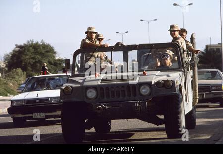 Erster Golfkrieg: 8. März 1991 auf der Arabian Gulf Street in Kuwait City schließen sich amerikanische Soldaten in einem offenen Humvee dem Volk an, das die Befreiung Kuwaits durch Koalitionstruppen feiert. Stockfoto