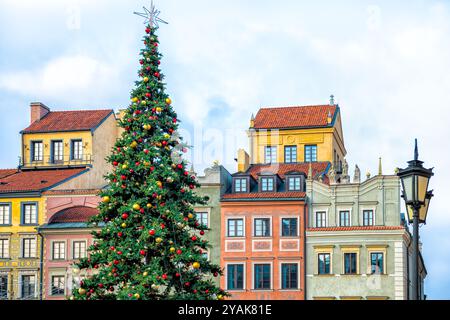 Weihnachtsbaum auf dem Warschauer Altstadtmarkt in Polen während des Neujahrs, dekoriert mit Beleuchtungsornamenten durch die bunte Architektur von Laternenpfosten Stockfoto