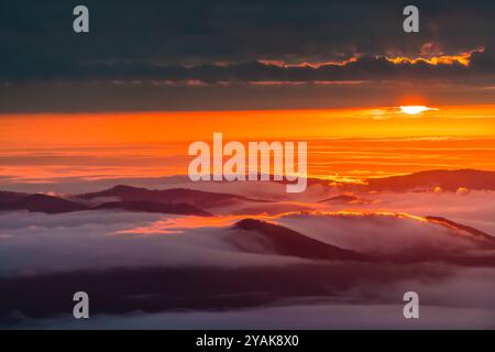 Wintergreen Resort, Virginia Sonnenaufgang der Sonne versteckt sich hinter Nebelwolken über den Blue Ridge Mountains im Herbst Stockfoto