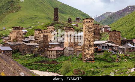 Das mittelalterliche Dorf ushguli mit vielen traditionellen Wehrtürmen liegt auf einem grasbewachsenen Hügel in den Bergen des kaukasus in georgien Stockfoto