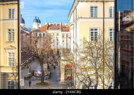 Lviv, Ukraine - 21. Januar 2020: Blick auf den historischen Marktplatz der ukrainischen Altstadt mit Geschäften und Menschen, die im Winter am Weihnachtsmarkt vorbeilaufen Stockfoto