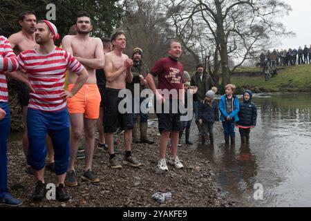 Am Neujahrstag feiern die Menschen das neue Jahr mit der Teilnahme am Okeover Bridge Jump. Sie springen in den Fluss Taube. Sie beobachten andere Springer. Mappleton Derbyshire 2020 2020er Jahre, Großbritannien HOMER SYKES Stockfoto