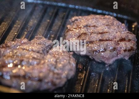 Zwei Beef Patties auf dem Grill Stockfoto