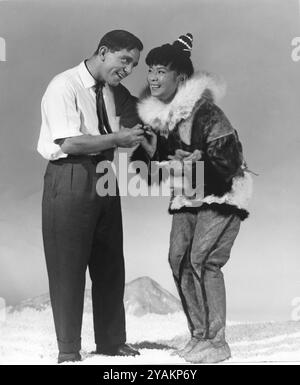 NORMAN WISDOM besucht die JAPANISCHE Schauspielerin YOKO TANI am Set der SAVAGE INNOCENT in den Pinewood Studios 1960 Regisseur NICHOLAS RAY Roman HANS RUESCH Fotografie von GEORGE COURTNEY WARD Societe Nouvelle Pathe Cinema / Appia Films / Gray-Film / Magic Film / The Rank Organization Stockfoto